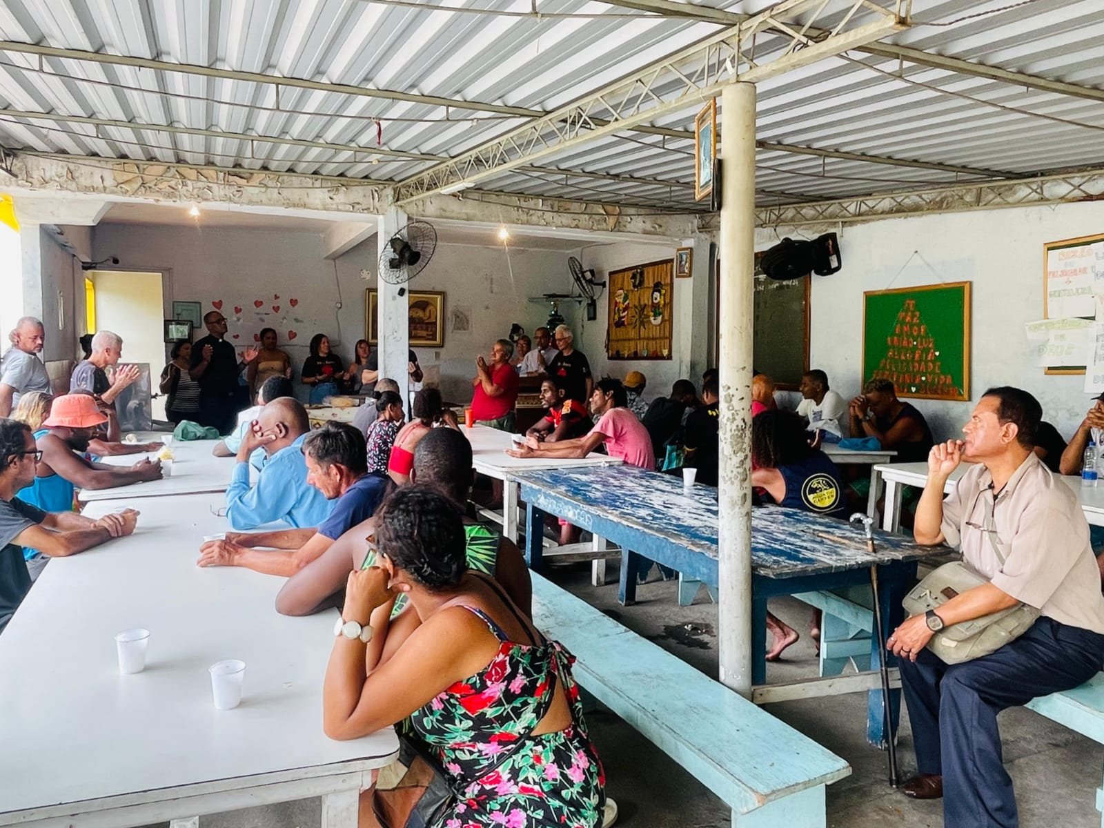 Refeitório da Casa da Solidariedade durante uma celebração, com acolhidos e voluntários reunidos nas mesas